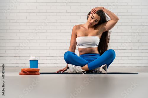 Guapa mujer deportista con mallas azules haciendo yoga y estiramientos 