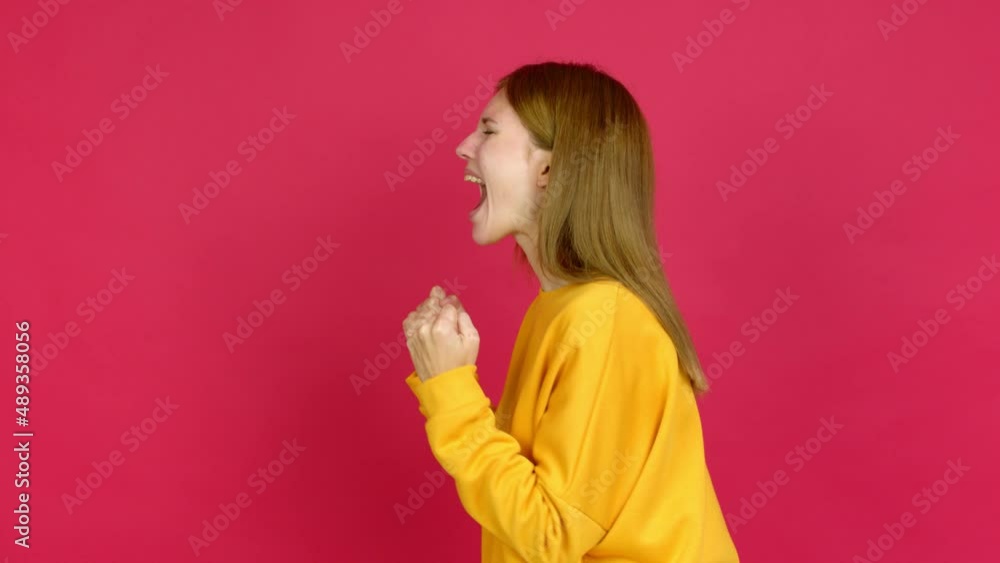 Young woman celebrating a victory over isolated background Young woman celebrating a victory over isolated background