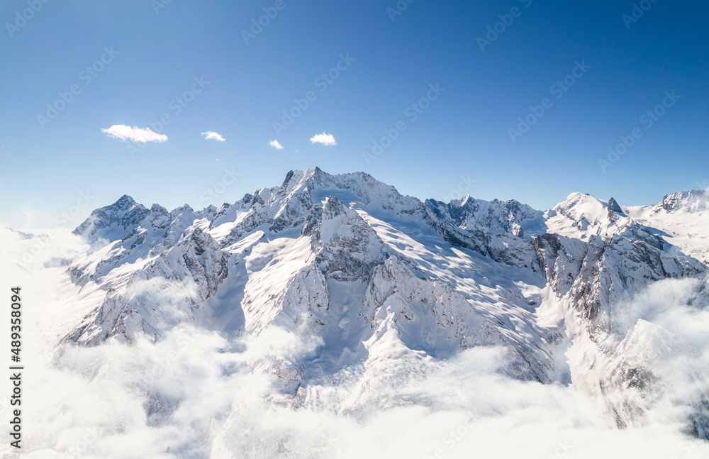 Naklejka premium Mountain range above the clouds and clear sky 