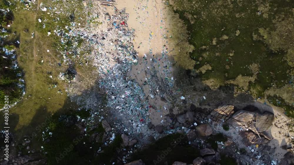 Aerial top down zoom in tropical sandy beach filled with plastic trash garbage waste, ocean pollution in Asia travel destination, climate change global warming concept Aerial top down zoom in tropical sandy beach filled with plastic trash garbage waste, ocean pollution in Asia travel destination, climate change global warming concept