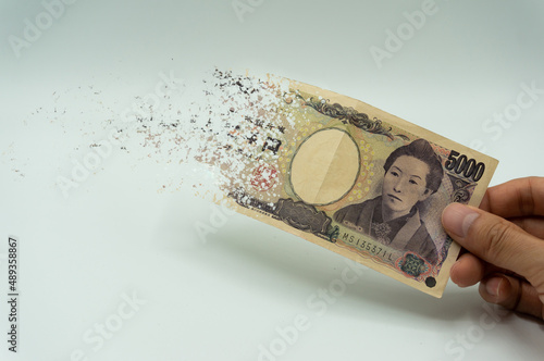 Tableau sur toile The man's hand holds a 5,000 yen, which crushes and flutters in the wind