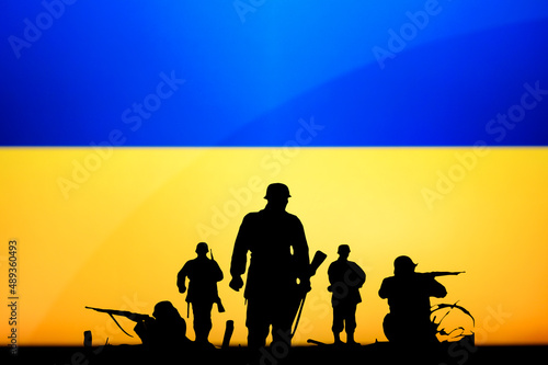 War in Ukraine. Russia attack Ukraine. Illustration Photo. Silhouette of Soldiers, National Flag in Background. Conflict in Europe photo
