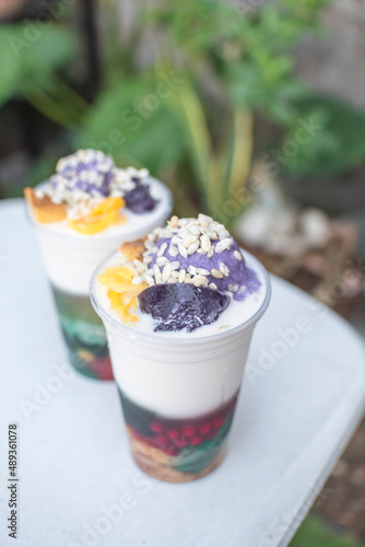 Two plastic cups of Halo-halo, a popular cold dessert in the Philippines, at an outdoor or al fresco cafe. Refreshing local snack. photo