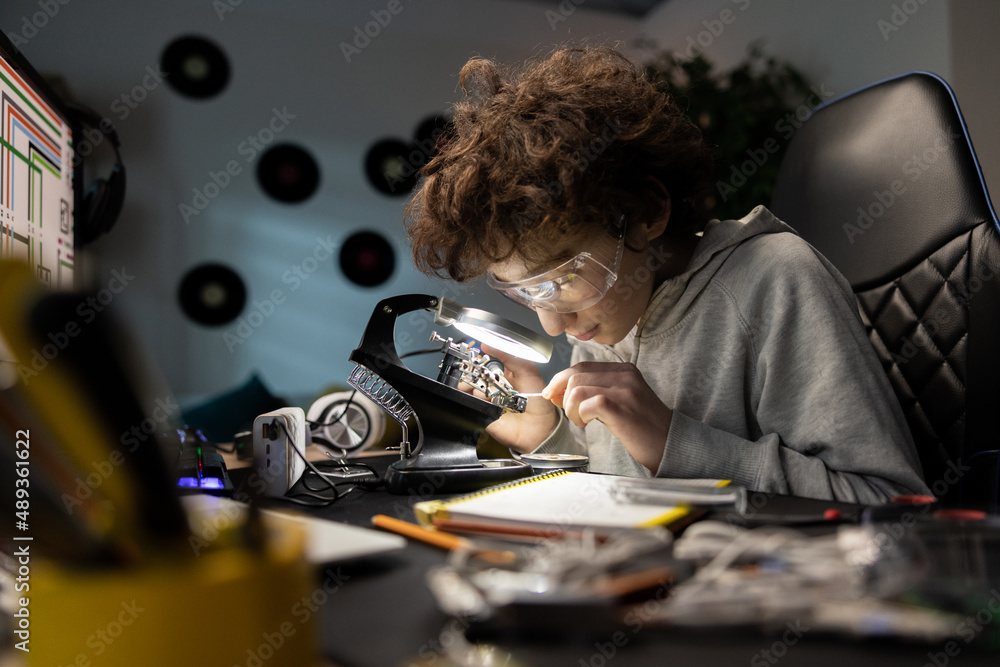 Little boy with safety glasses, future electronics technician, learning ...