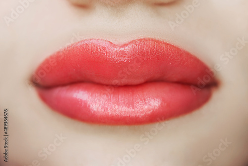 Close-up of lips after tattoo with coloring pigment, permanent makeup of woman's lips in beauty salon, beauty and health