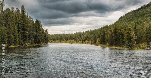 Panorama of wild northern nature with coniferous forests and a calm quiet river. A great place for fishing or hunting or hiking