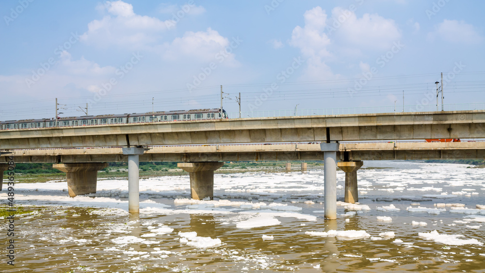 View of a newly build metro rail bridge by Delhi Metro and polluted Yamuna river
