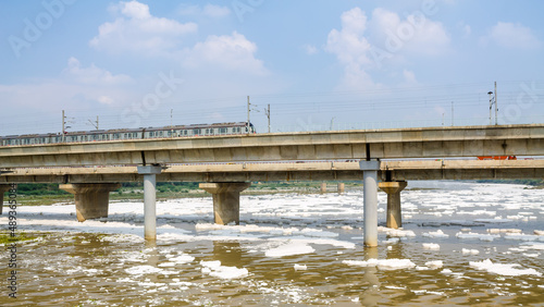 View of a newly build metro rail bridge by Delhi Metro and polluted Yamuna river photo