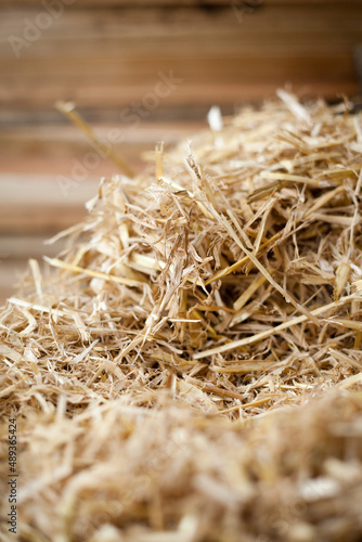 Building a House with Straw bales and red Clay -  mixing ingredients on the building site -  walls made from straw bales covered with clay straw mix.