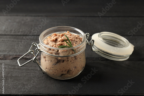 Glass jar of pate on wooden background