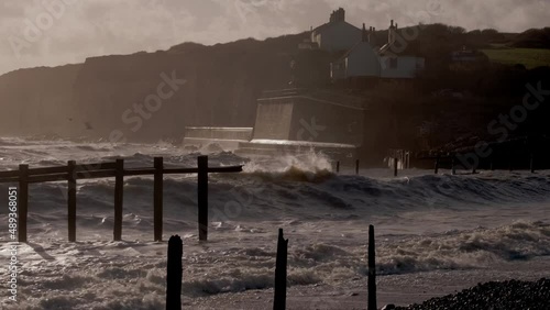 Waves batter coastguard cottages at Cuckmere Haven, England photo