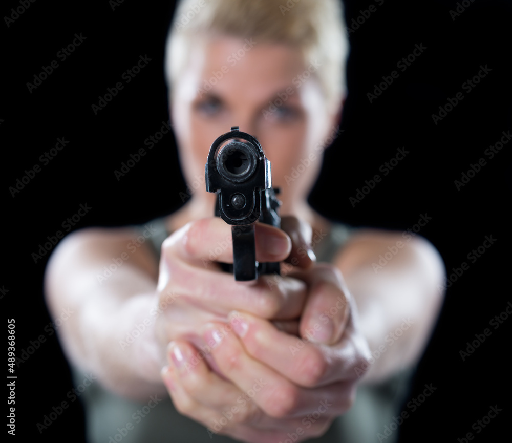 Young woman shooting with gun isolated on black background Young woman shooting with gun isolated on black background