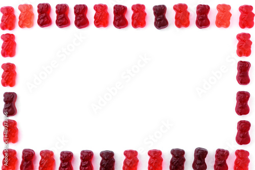 Small gummy bears red and brown on white isolated background framed, in the middle place for text, copy space