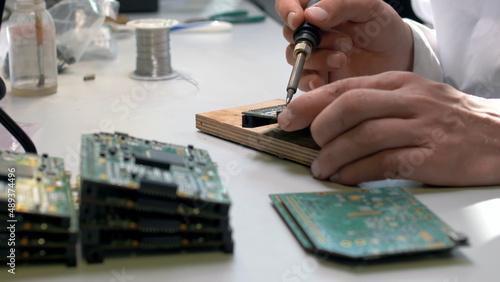 Close up of technician repair circuit board in lab.