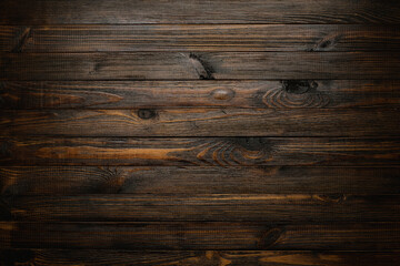 Dark stained wooden table background, rustic wood planks  texture top view.