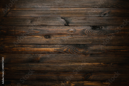 Dark stained wooden table background, rustic wood planks  texture top view.