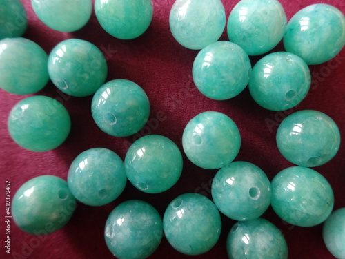 Green Gemstone Beads on Red Background photo