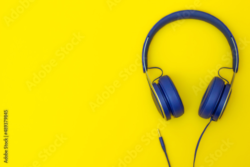 Blue headphones on yellow background
