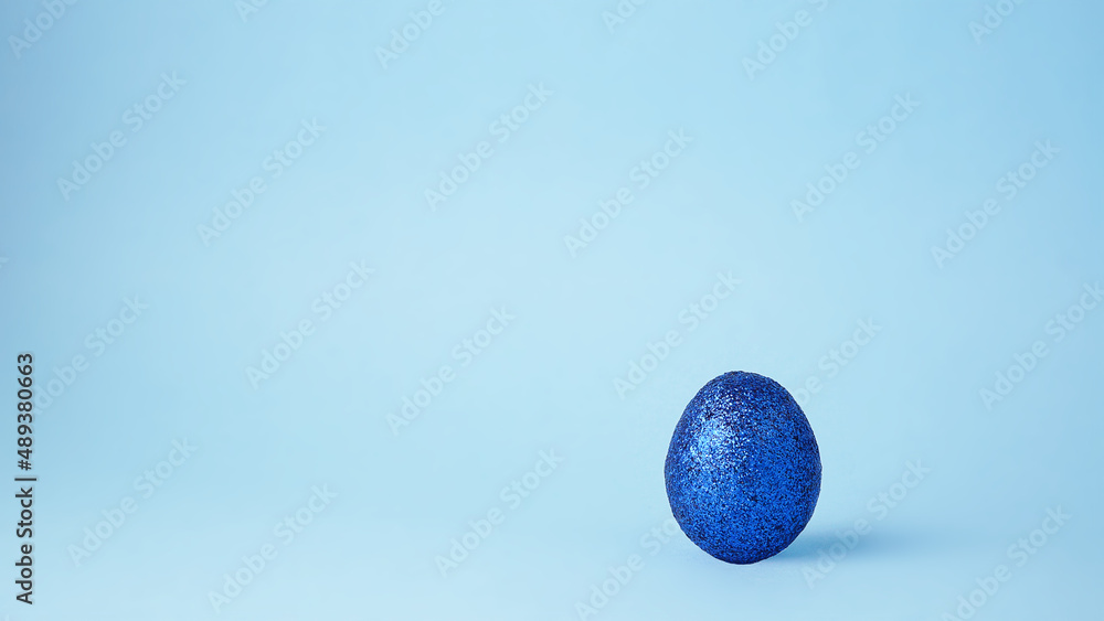 Blue glitter Easter egg. Minimal wealth luxury concept. 
Space for text.