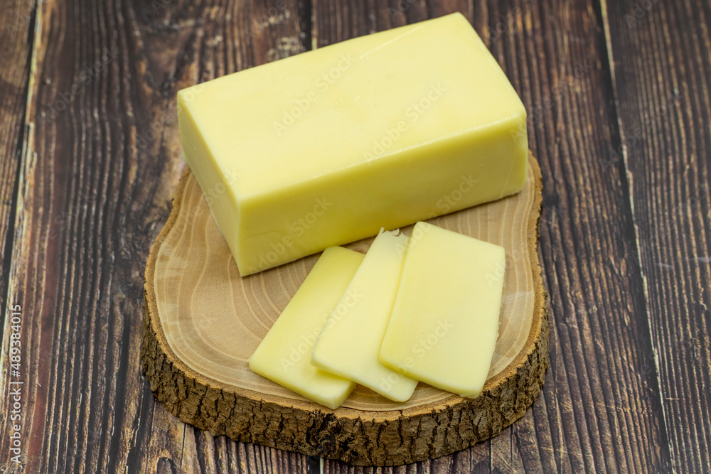 Kashar cheese or kashkaval cheese on wooden background. Sliced Cheddar Cheese