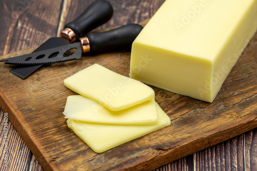 Kashar cheese or kashkaval cheese on wooden background. Sliced Cheddar Cheese