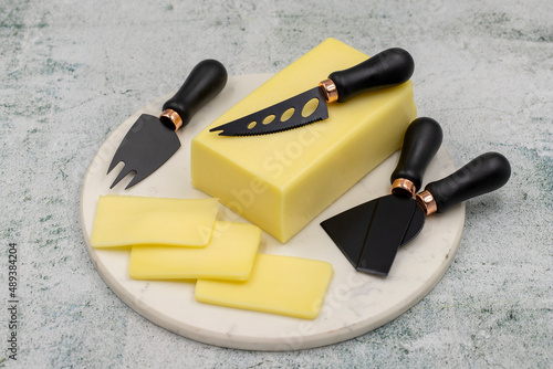 Kashar cheese or kashkaval cheese on stone background. Sliced Cheddar Cheese photo