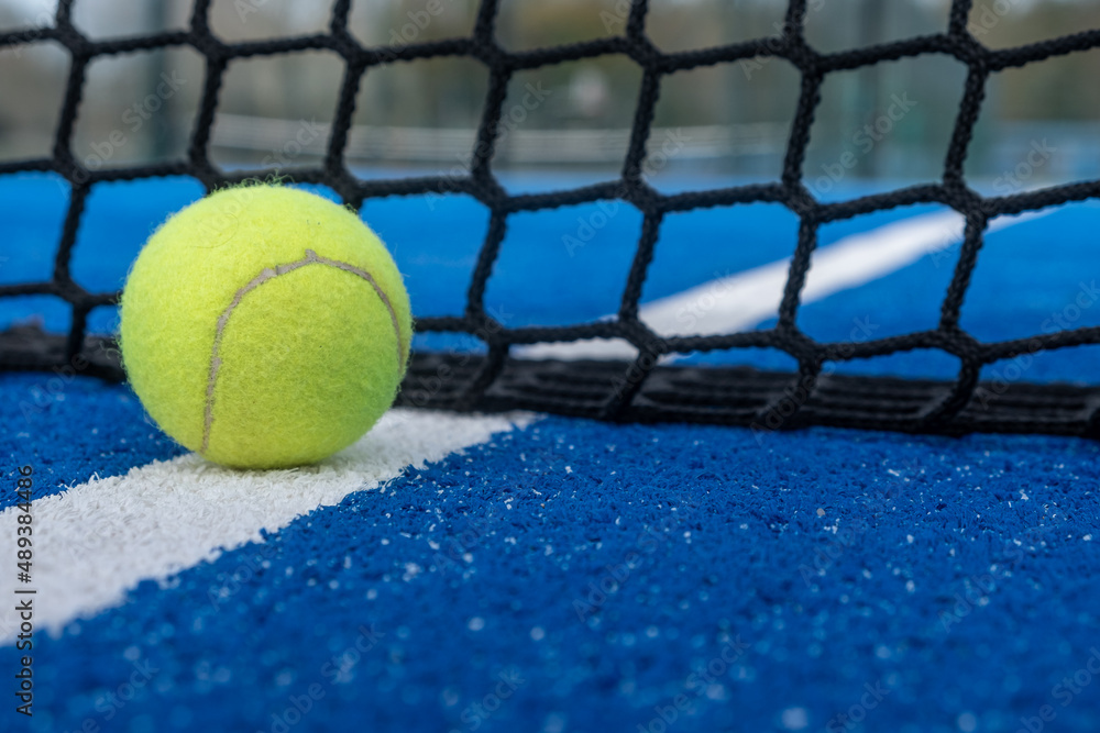 Yellow ball on floor paddle net in blue outdoors. Stock Photo | Adobe Stock