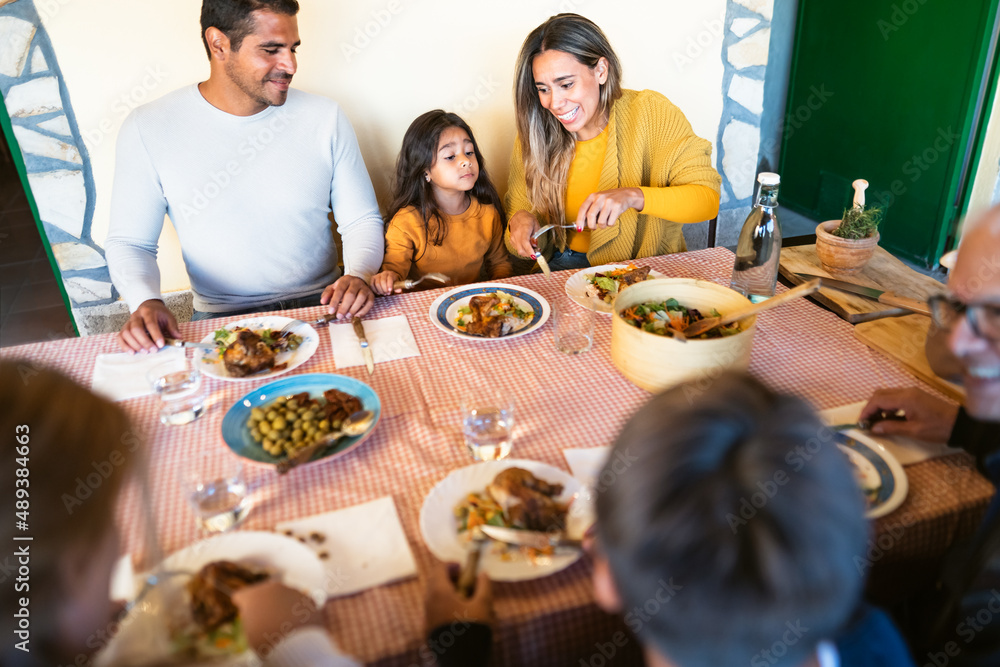 Happy Latin family having fun lunching together at home Happy Latin family having fun lunching together at home