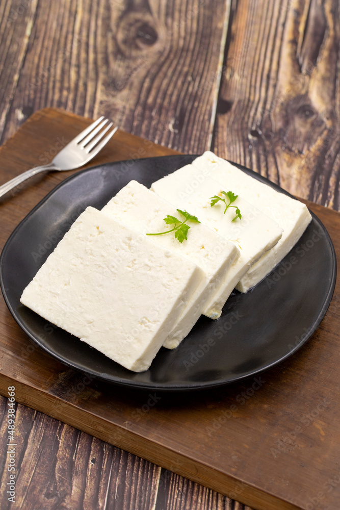 Sliced Feta cheese with herbs on wooden background. Close-up breakfast cheese Sliced Feta cheese with herbs on wooden background. Close-up breakfast cheese