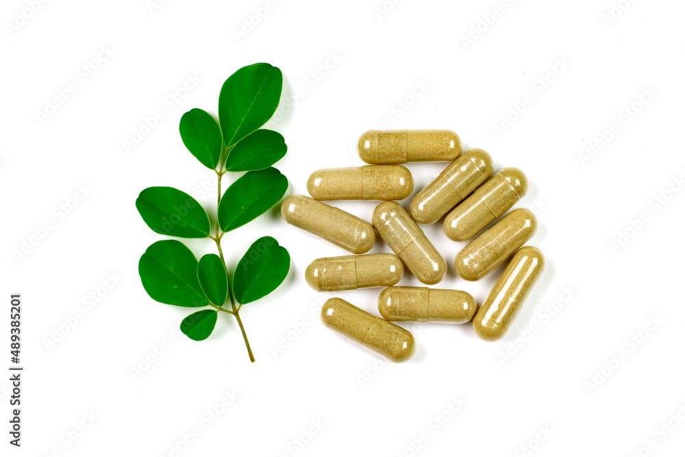 Moringa oleifera capsule with moringa leaf isolated on white background. Moringa oleifera capsule with moringa leaf isolated on white background.