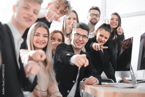 close up. a group of young employees pointing at you