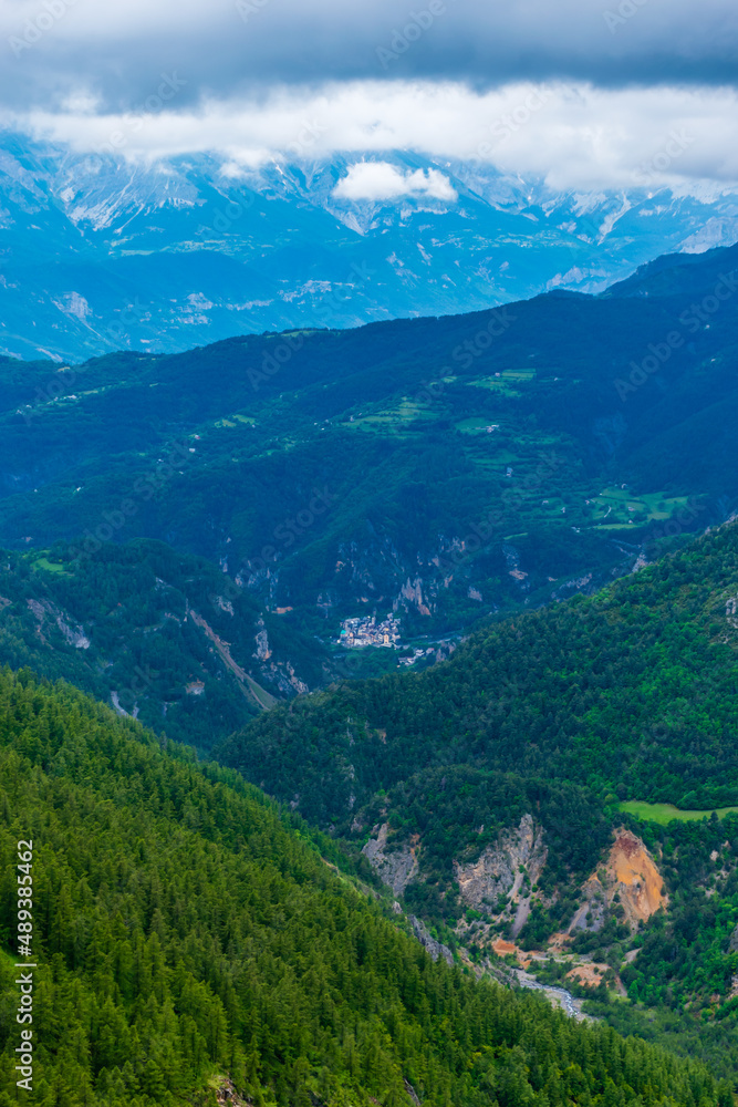 A picturesque vertical landscape view of the French Alps mountains on a cloudy summer day (Valberg, Alpes-Maritimes, France)