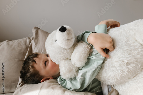 Cute girl with toy on bed photo