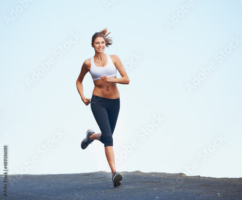 Fototapeta Naklejka Na Ścianę i Meble -  Fresh and fit female. Shot of a sporty young woman enjoying a run outdoors.