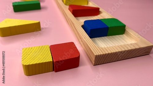 Wooden colorful game with geometric shapes for the development of children in kindergarten