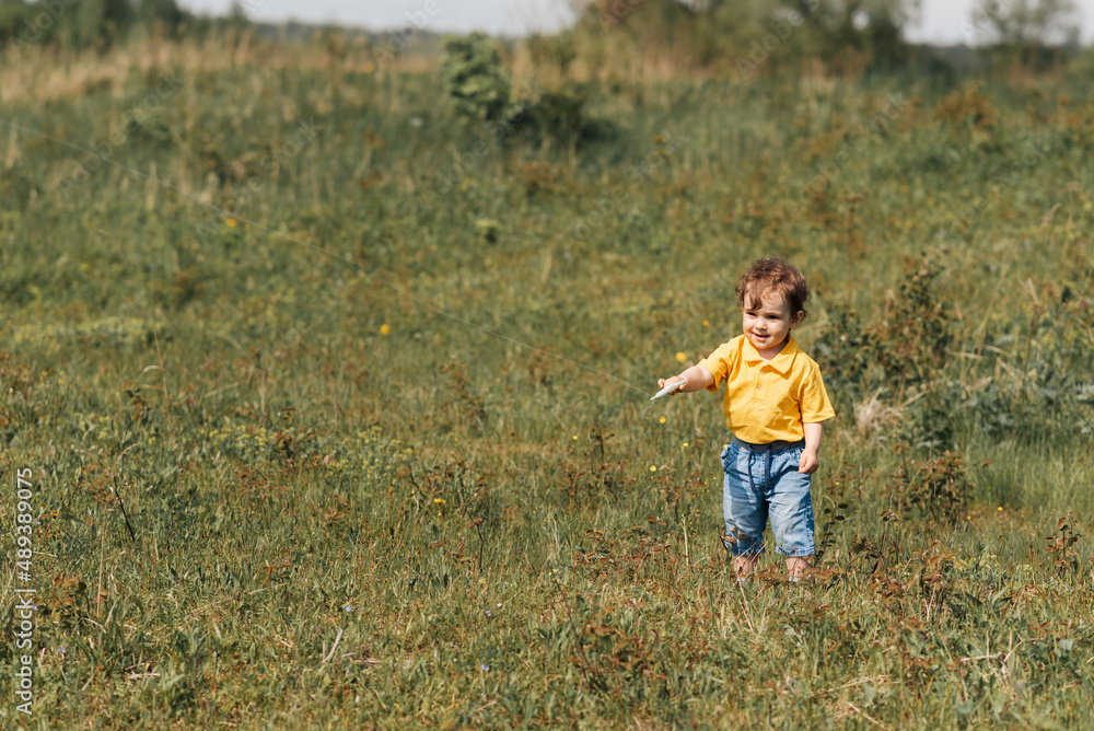 happy boy runs outdoors with a kite happy boy runs outdoors with a kite