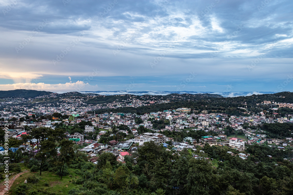 downtown city view with dramatic cloudy sky at evening from mountain top