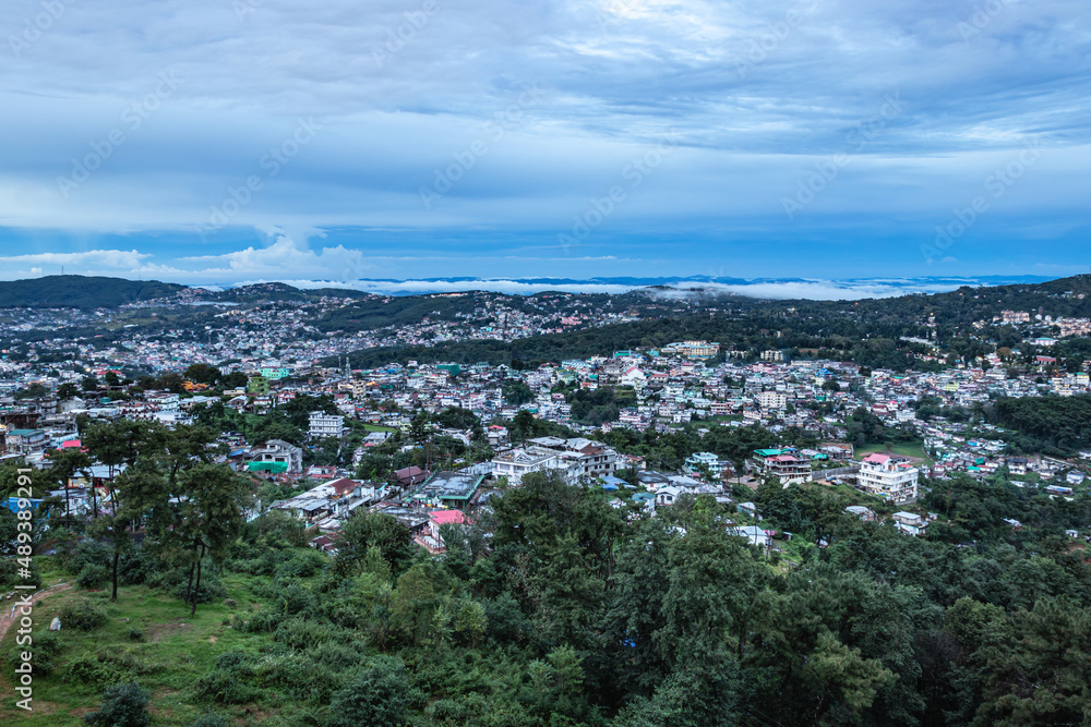 downtown city view with dramatic cloudy sky at evening from mountain top
