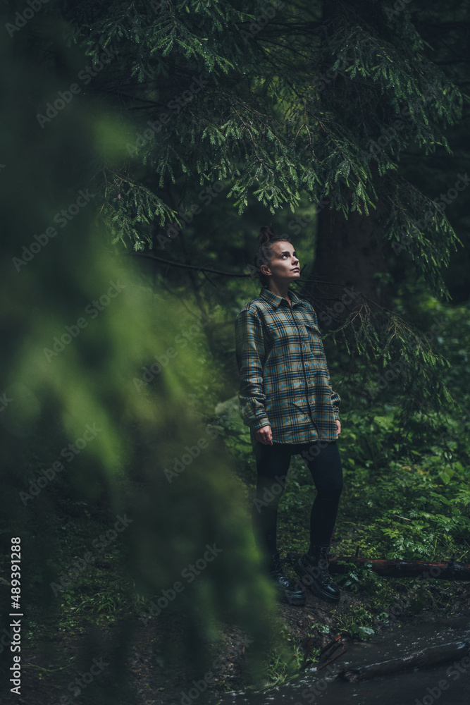 Girl wearing a flannel shirt in the woods