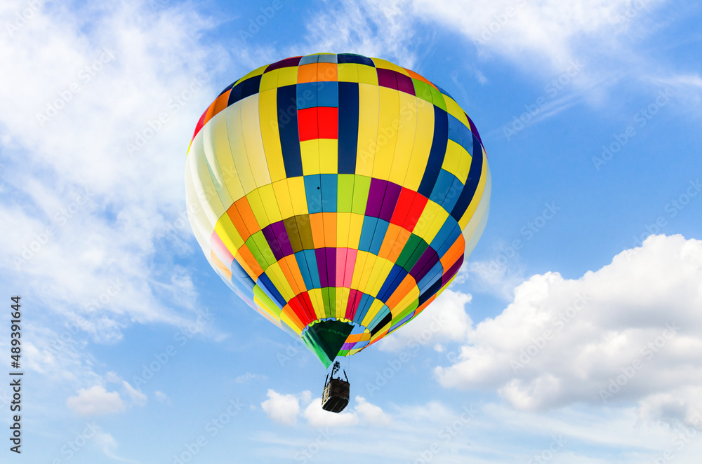 Fototapeta premium Colorful hot air balloon, flying over a blue sky