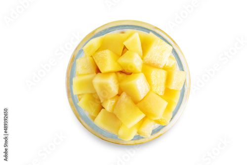 Greek yogurt with mango slices in a glass on a white isolated background