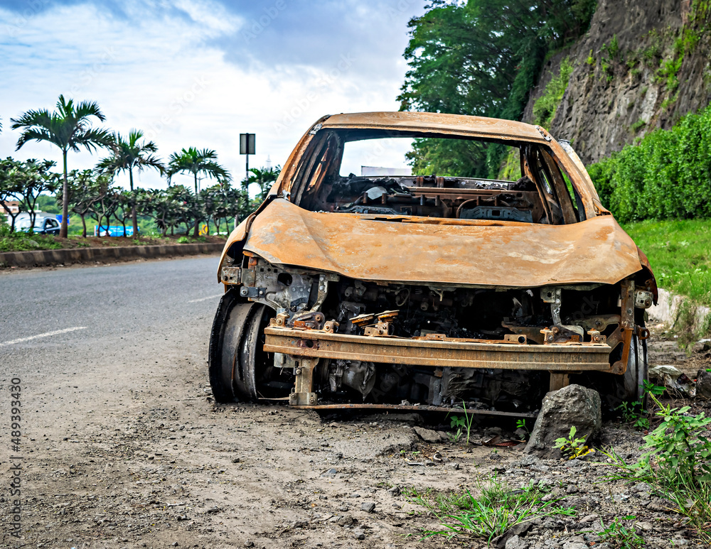 Abandoned burnt car remains on the side of the road Abandoned burnt car remains on the side of the road