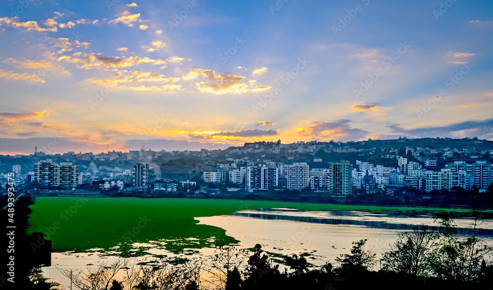 Naklejka premium Beautiful Sunrise over tall buildings and Jambhulwadi lake in Pune, Maharashtra, India