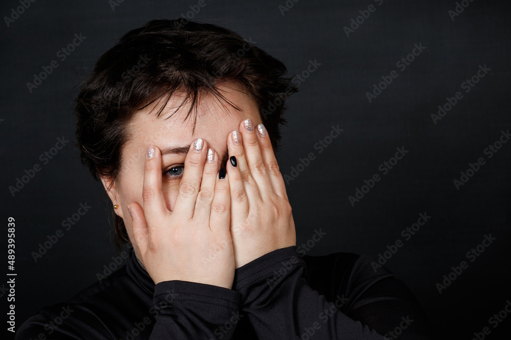 caucasian woman in despair covered her face with her hands on a black background caucasian woman in despair covered her face with her hands on a black background