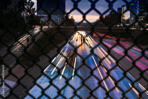 Urban landscape shot behind a chain link fence at a los Angeles freeway