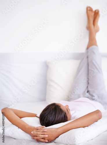 Morning relaxation. Rearview shot of a young woman sleep with her legs propped up on a pillow.