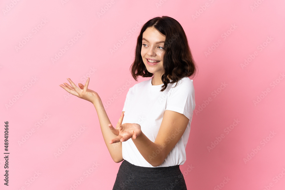 Teenager Ukrainian girl isolated on pink background with surprise expression while looking side Teenager Ukrainian girl isolated on pink background with surprise expression while looking side