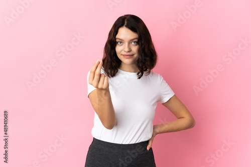 Teenager Ukrainian girl isolated on pink background making Italian gesture