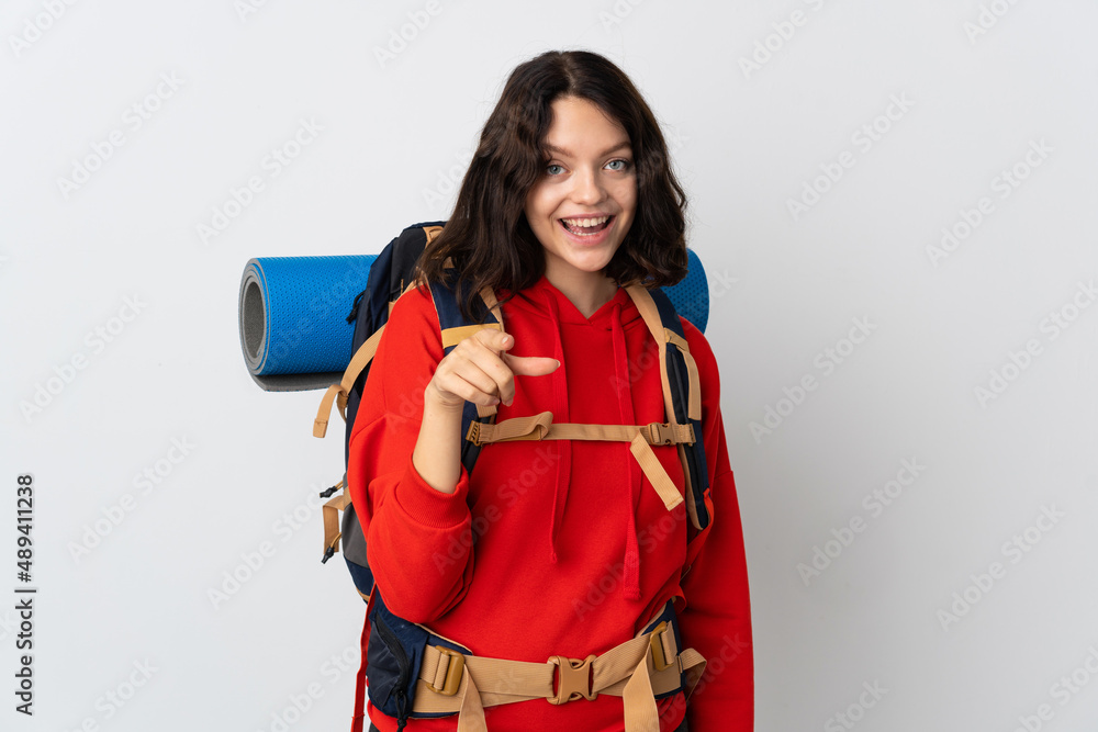 Teenager mountaineer girl with a big backpack isolated on white background surprised and pointing front Teenager mountaineer girl with a big backpack isolated on white background surprised and pointing front