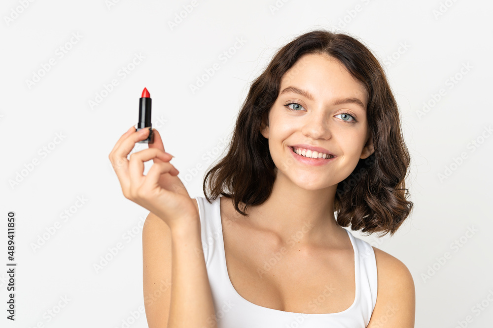 Teenager Ukrainian girl isolated on white background holding red lipstick Teenager Ukrainian girl isolated on white background holding red lipstick